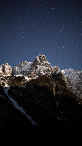 a mountain covered in snow under a night sky at ETHNO STAR Bojović in Gusinje