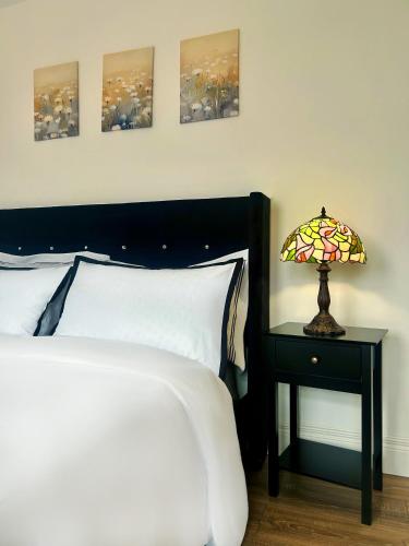 a bedroom with a bed and a table with a lamp at Stay in City Centre 2 in Belfast