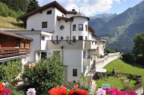 a white building with flowers in front of it at Gschlössle Ferienwohnungen in Jerzens