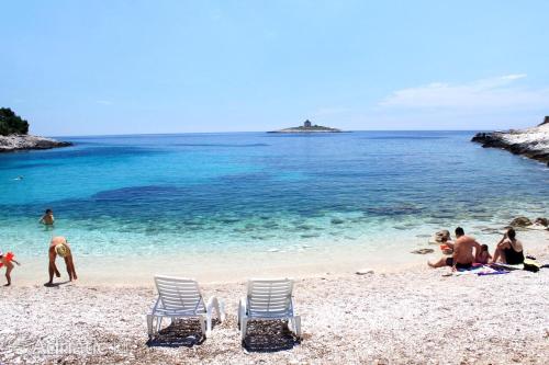 a group of people sitting on a beach at Hotel - Teranea City Hvar in Hvar