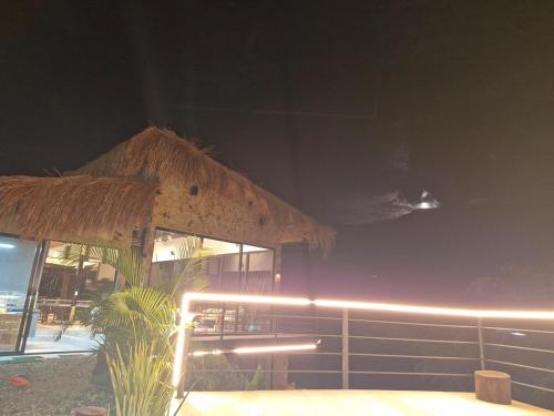 a building with a straw umbrella and a table and chairs at Limoncello House - a Breath in the Mountains in Villeta