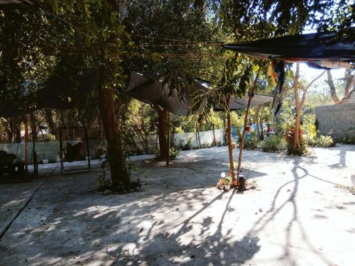 a shady area with trees and an umbrella at SECLUDED GLAMPING YOGA SAMADHI fan 2 kubos 8 pax in Rimus