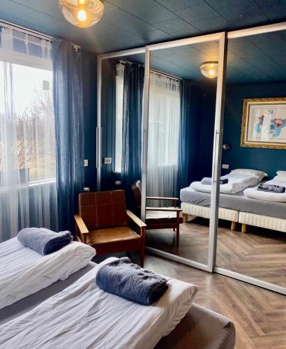 a room with two beds and a mirror at Enchanting country home in Laugaras
