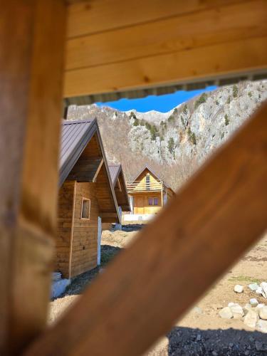 a view of a log cabin through a wooden fence at ETHNO STAR Bojović in Gusinje
