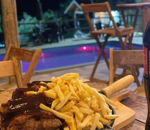 a plate of food with french fries on a table at Chalé Bella Serra piscina café da manhã incluso in Jaboticatubas