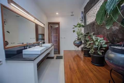 a large bathroom with two sinks and potted plants at Villa Senja in Nusa Lembongan