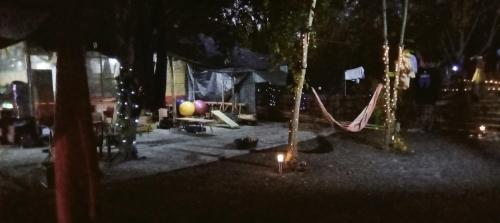 a park with a hammock and trees at night at SECLUDED GLAMPING YOGA SAMADHI fan 2 kubos 8 pax in Rimus