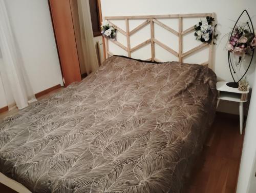 - un lit dans une chambre avec une couette brune dans l'établissement Villa évasion, à Ambillou