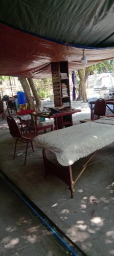 a tent with a bed and chairs and tables at SECLUDED GLAMPING YOGA SAMADHI fan 2 kubos 8 pax in Rimus