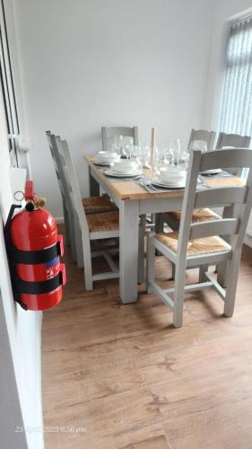 a dining room table with chairs and a fire hydrant at Stylish 3-Bed house NEC-JLR-Airport-HS2-Driveway in Birmingham