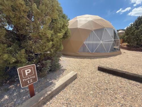 a sign in front of a large dome tent at Bryce Glamp And Camp in Cannonville