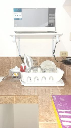 a kitchen counter with a microwave on a shelf at Apartamento vacacional in Manta