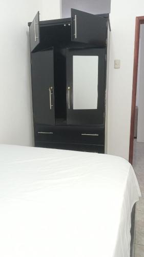 a tv sitting on a dresser next to a bed at Apartamento vacacional in Manta