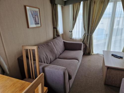 a living room with a couch and a table at The Lookout 3 Bedroom Family Caravan with Sea View Pet Friendly in Aberystwyth