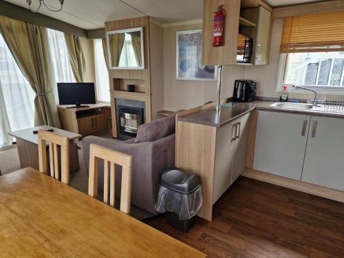 a kitchen and living room with a couch and a table at The Lookout 3 Bedroom Family Caravan with Sea View Pet Friendly in Aberystwyth