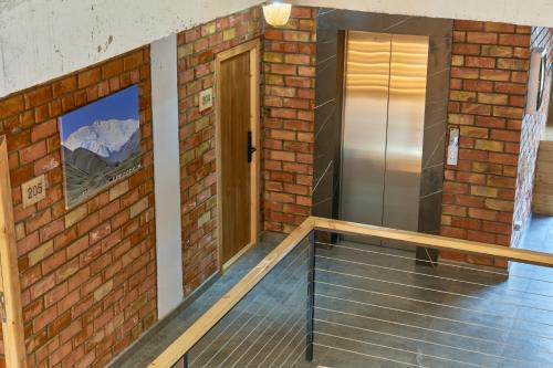 an empty room with a brick wall and a door at Pristine Hotel in Bishkek