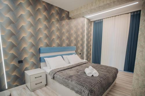 a bedroom with a bed with two white shoes on it at Sabah Bayil Residence Family Apart in Baku
