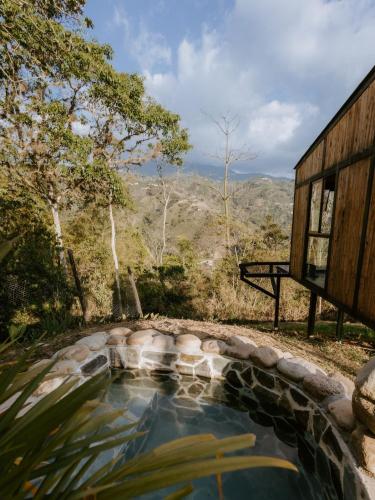 a hot tub in a garden next to a building at Copoazú Glamping in Floridablanca