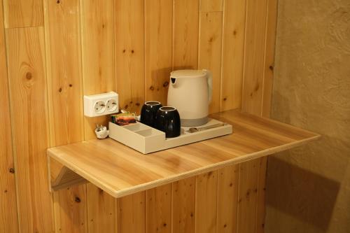 a counter with a coffee maker on a wooden wall at Pristine Hotel in Bishkek