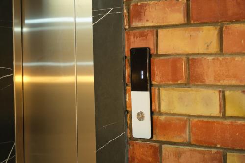 a brick wall with a stainless steel refrigerator at Pristine Hotel in Bishkek