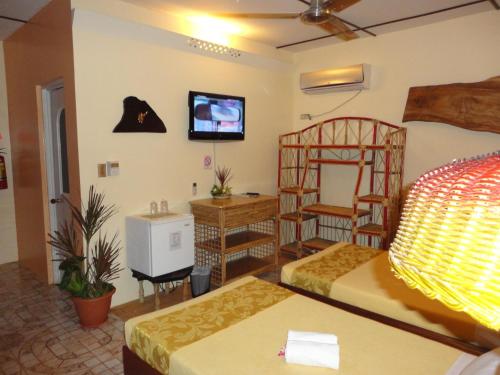 a hotel room with two beds and a tv at Deep Forest Garden Hotel in Puerto Princesa City