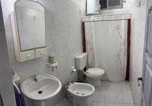 a white bathroom with a sink and a toilet at Casa en Paso II in Paso de la Patria