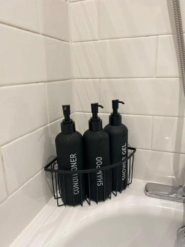 three black bottles sitting on top of a bathroom sink at Manchester Central - Modern Apartment - Free Parking in Manchester