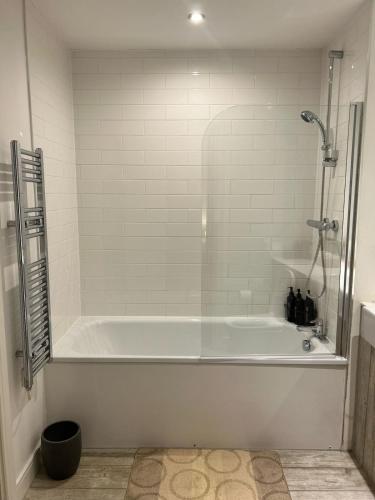 a white bath tub in a bathroom with a shower at Manchester Central - Modern Apartment - Free Parking in Manchester