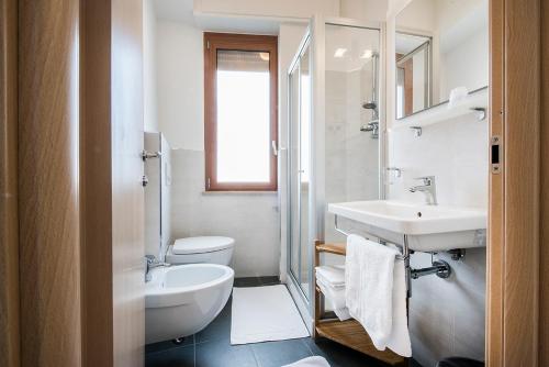 La salle de bains blanche est pourvue d'un lavabo et de toilettes. dans l'établissement Stella Hotel, à Sirolo