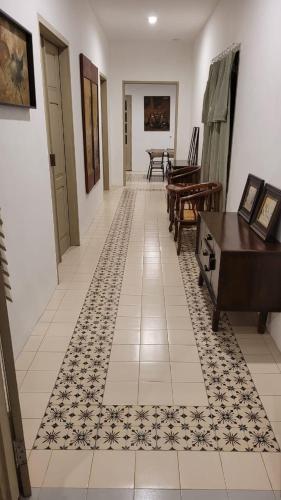 a hallway with a piano and a tiled floor at Kosasih 1919 A Dutch-Retro House in Banyuwangi