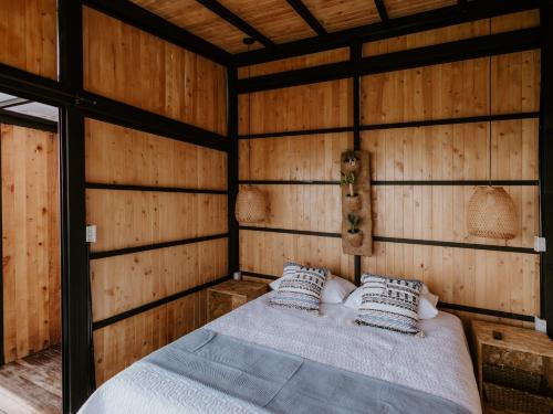 a bedroom with a bed in a wooden room at Copoazú Glamping in Floridablanca