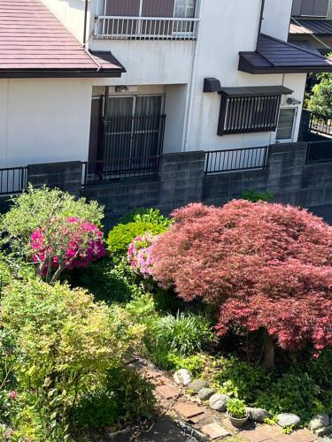 a garden of flowers in front of a building at サンムーン鶴間 in Yamato
