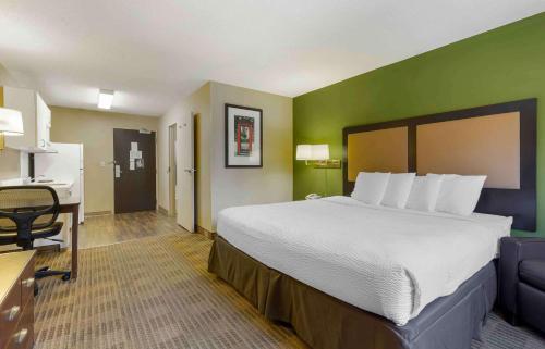a hotel room with a large bed and a desk at Extended Stay America Suites - Hartford - Meriden in Meriden