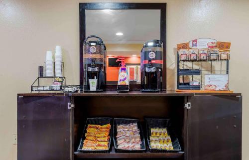 エリザベスにあるエクステンデット ステイ アメリカ エリザベス ニューアーク エアポートの鏡の前にある食べ物が置かれた棚