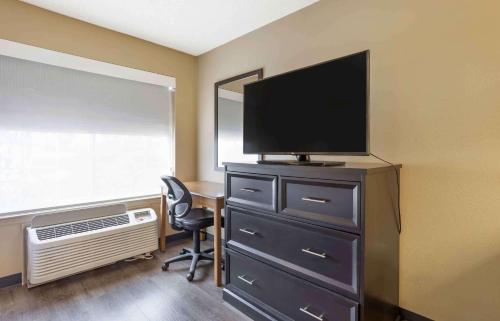 a room with a dresser with a television and a chair at Extended Stay America Suites - Meadowlands - East Rutherford in East Rutherford