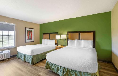 two beds in a hotel room with green walls at Extended Stay America Suites - Meadowlands - East Rutherford in East Rutherford
