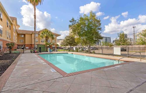 a swimming pool in front of a building at Extended Stay America Suites - Houston - Med Ctr - NRG Park - Braeswood Blvd in Houston