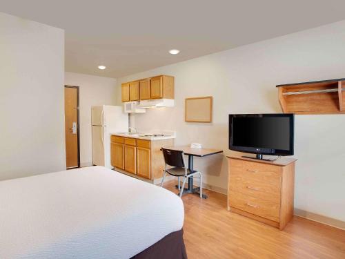 a room with a bed and a kitchen with a television at Extended Stay America Select Suites - Mobile - I-65 in Mobile