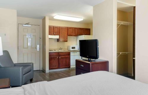 a room with a bed and a tv and a kitchen at Extended Stay America Select Suites - Austin - Northwest - Research Park in Austin