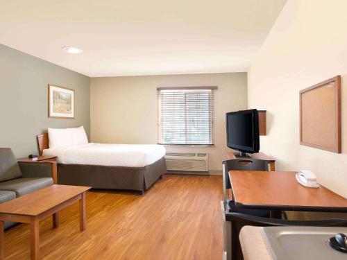 a hotel room with a bed and a tv at Extended Stay America Select Suites - Mobile - I-65 in Mobile