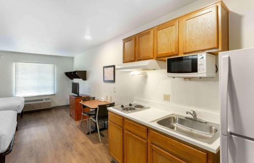a kitchen with a sink and a refrigerator at Extended Stay America Select Suites - Salt Lake City - West Valley City in West Valley City