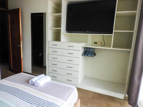 a living room with a tv and a white dresser at Casa moderna con Piscina, Iquitos in Iquitos