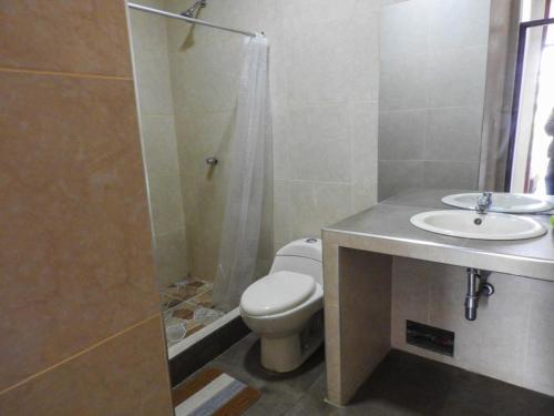a bathroom with a toilet and a shower and a sink at Casa moderna con Piscina, Iquitos in Iquitos