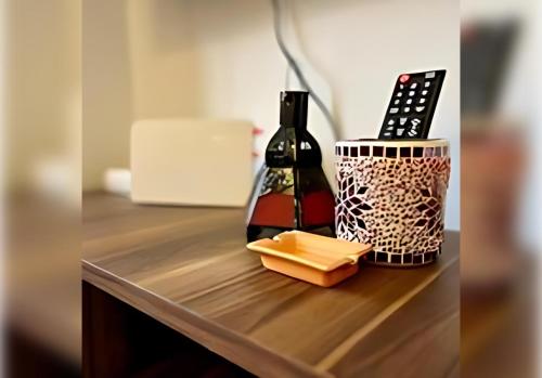 a counter with a bottle of wine and a remote control at Ehden Properties - Appt spacieux dans la prestigieuse River Palm Marrakech in Marrakech