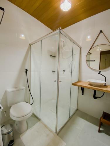 a bathroom with a toilet and a glass shower at Kwati Villa in Parintins