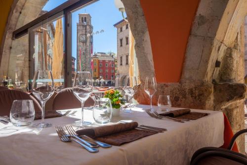 einen Tisch mit Weingläsern und Stadtblick in der Unterkunft Hotel Portici - Romantik & Wellness in Riva del Garda