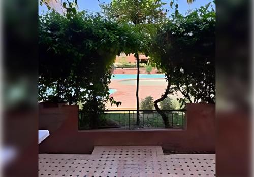 a view of a baseball field through a window at Ehden Properties - Appt spacieux dans la prestigieuse River Palm Marrakech in Marrakech