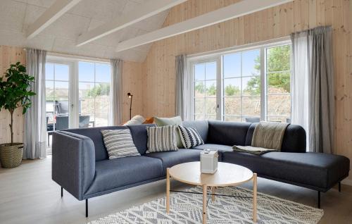 a blue couch in a living room with a table at Amazing Home In Henne With Kitchen in Henne Strand