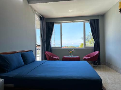 a bedroom with a blue bed and a large window at SnS Muine Homestay in Mui Ne