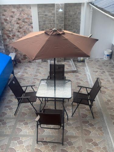 a table and chairs with an umbrella on a patio at Hotel Valle del Café - Habitación 8 Grupo 2 Camas in Sevilla